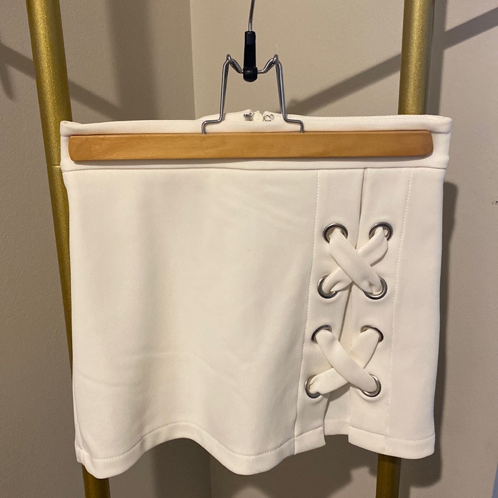 White mini skirt, shorts underneath. Silver details on side.